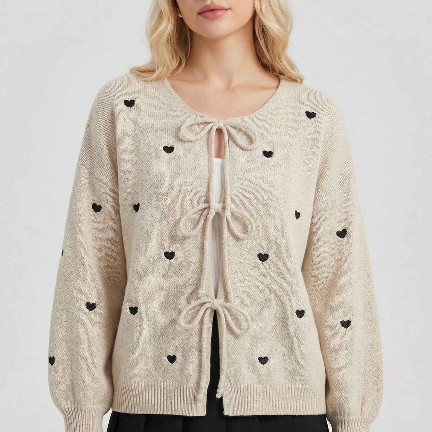 Knit cardigan with small black heart pattern and three front tie bows