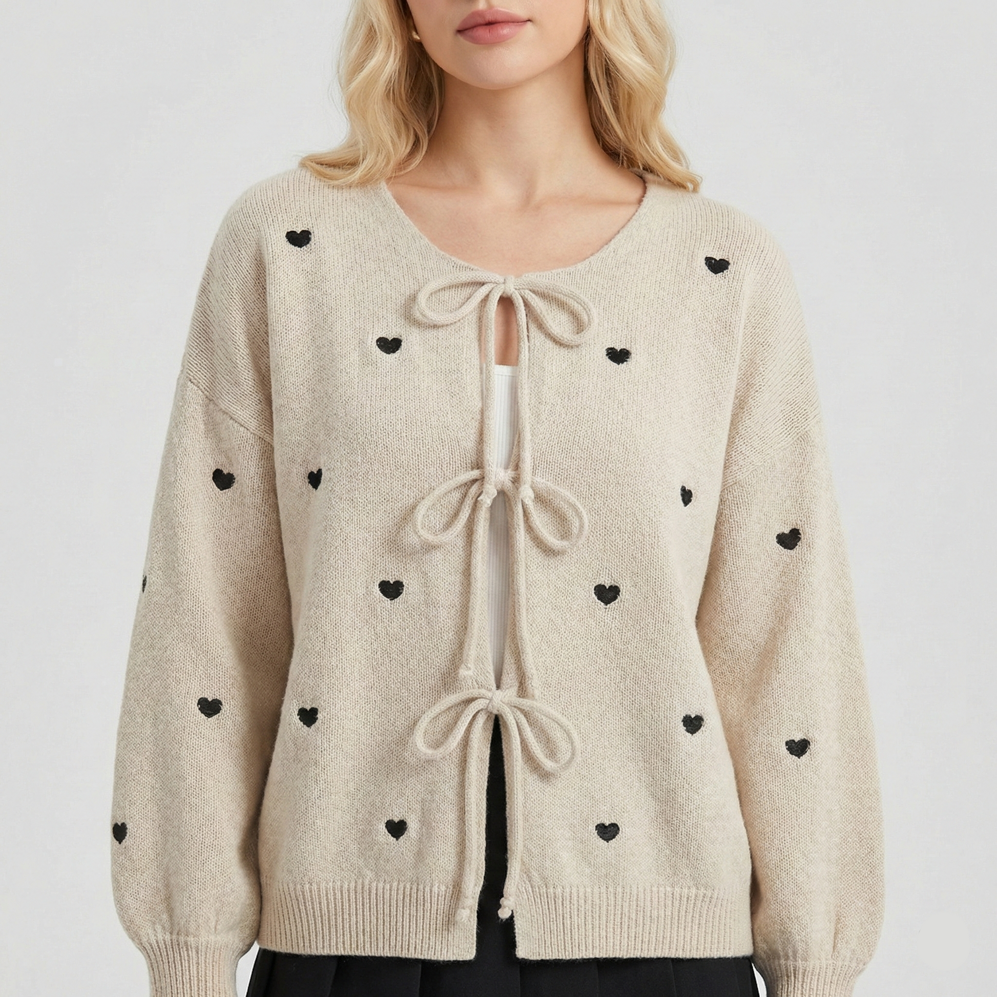 Knit cardigan with small black heart pattern and three front tie bows