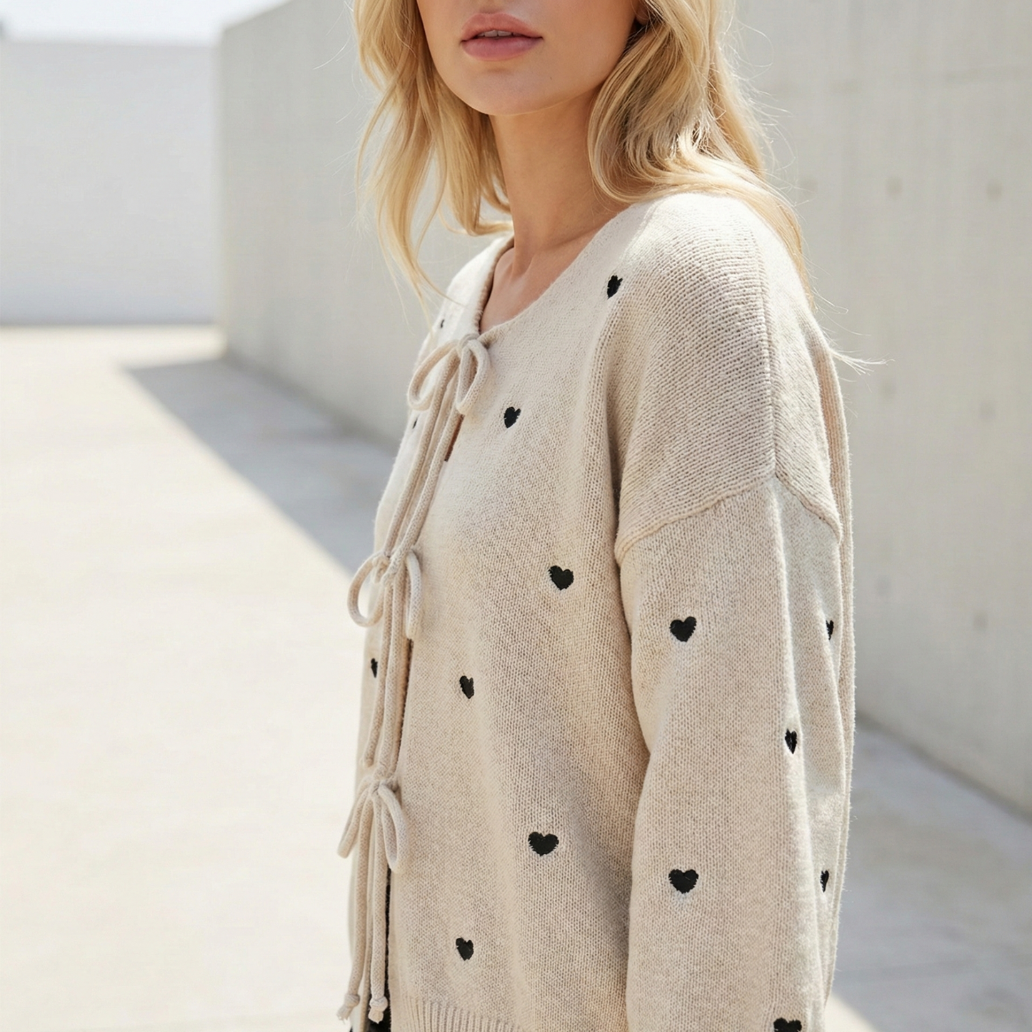 Knit cardigan with small black heart pattern and three front tie bows