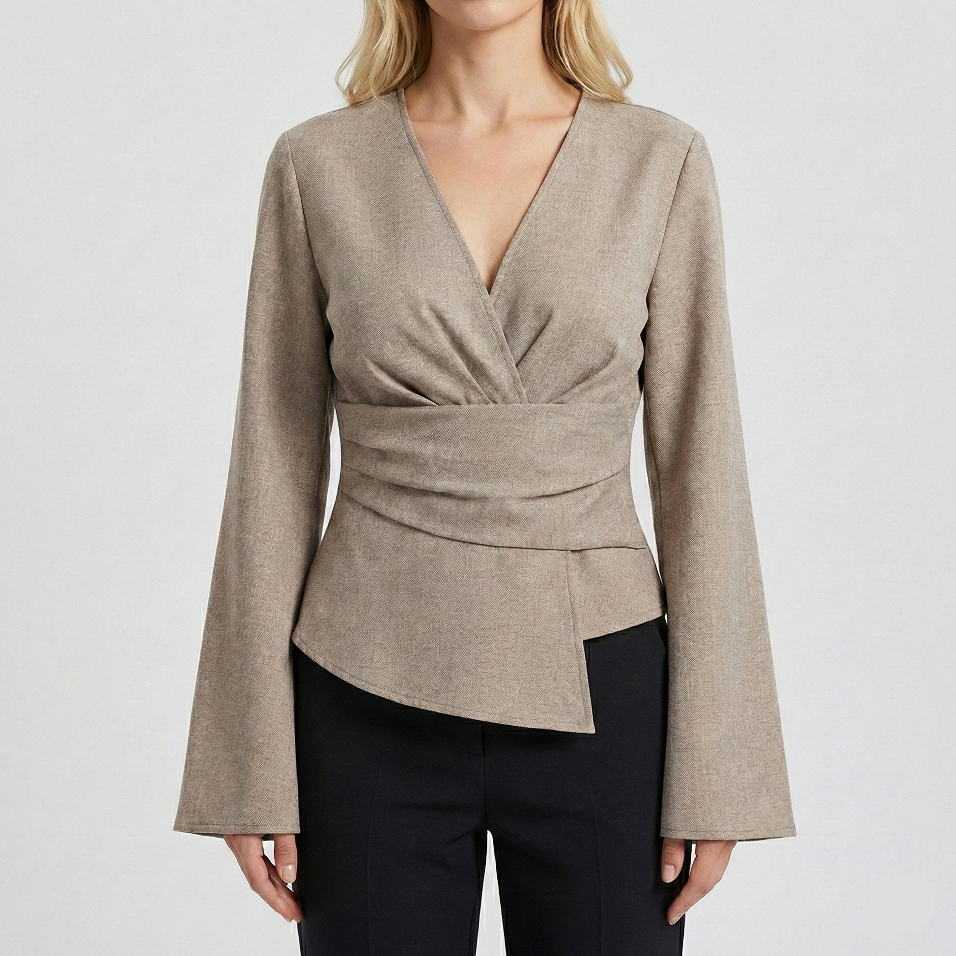 Tailored wrap-style blouse with a V-neckline and long bell sleeves, featuring a pleated waist detail and asymmetrical hem.