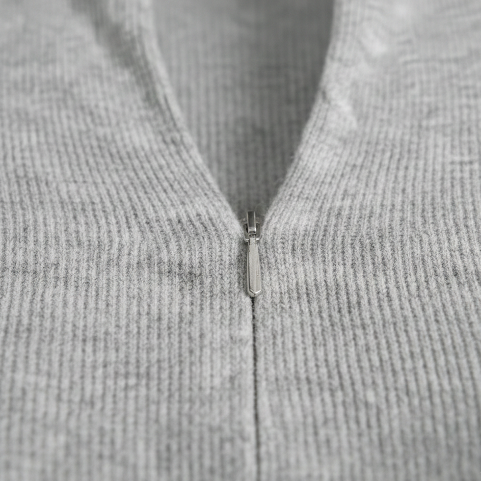 Textured knit top with a mock neckline and front zipper, featuring long sleeves and a form-fitting silhouette.