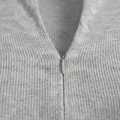 Textured knit top with a mock neckline and front zipper, featuring long sleeves and a form-fitting silhouette.